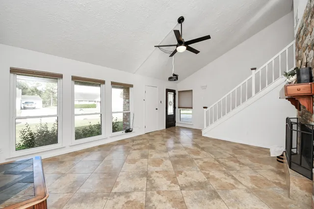 a view of empty room with stairs and windows