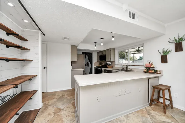 a large kitchen with a large counter top appliances and cabinets