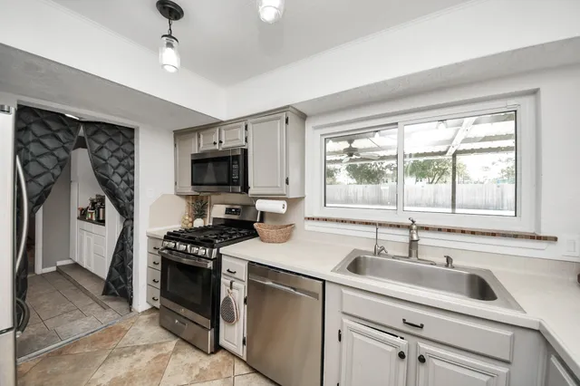 a kitchen with stainless steel appliances granite countertop a sink stove and refrigerator