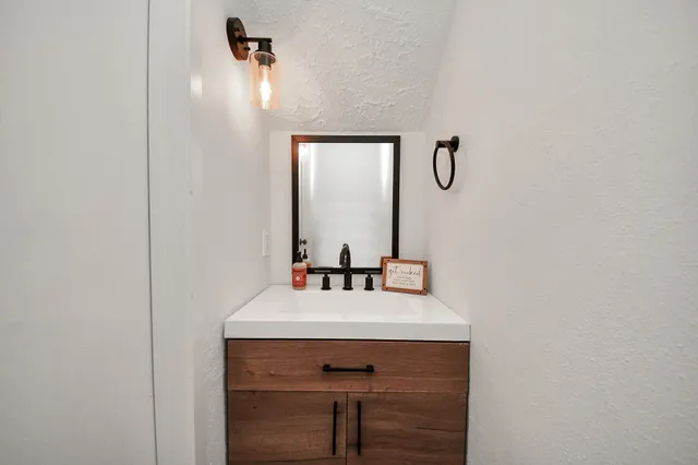 a bathroom with a sink a mirror and a vanity