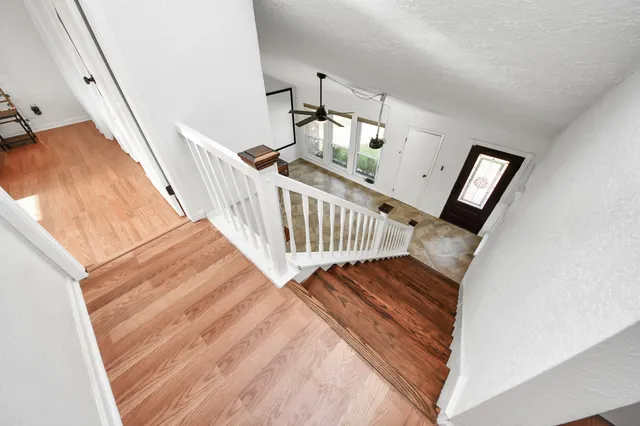 a view of staircase with white walls and railing