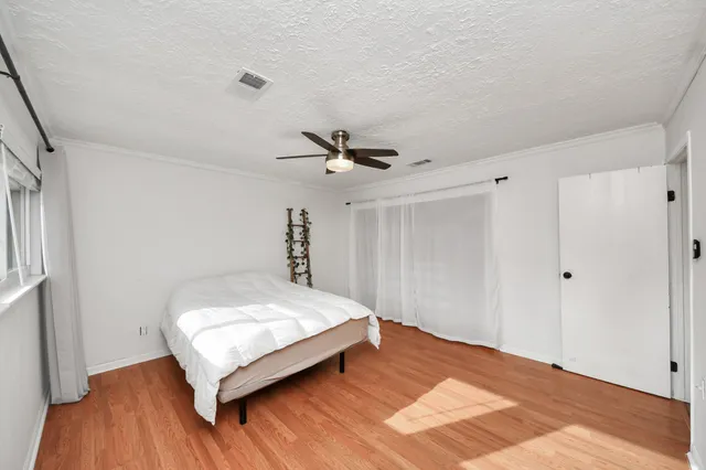 a bedroom with a bed and a ceiling fan