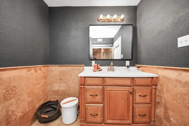 a bathroom with a granite countertop toilet sink and mirror