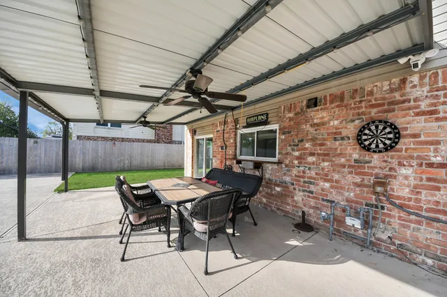 a patio with table and chairs with wooden floor