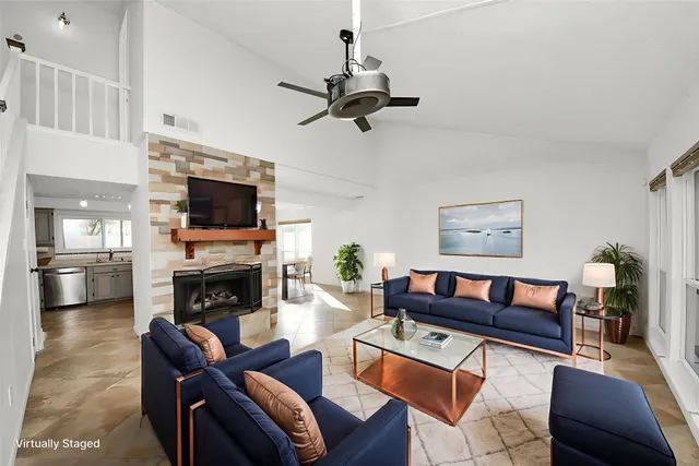 a living room with furniture a fireplace and a flat screen tv