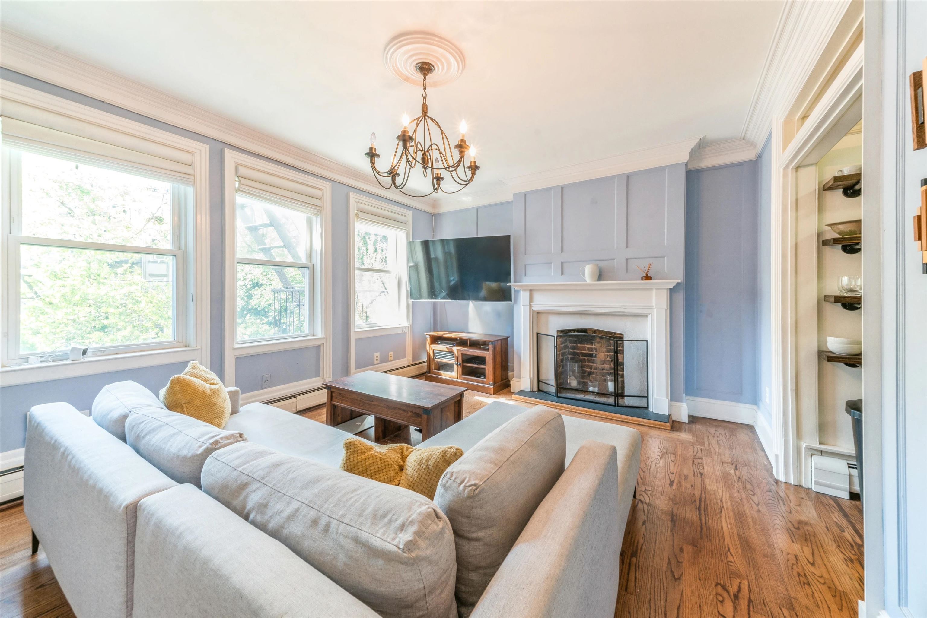 a living room with furniture a fireplace and a chandelier