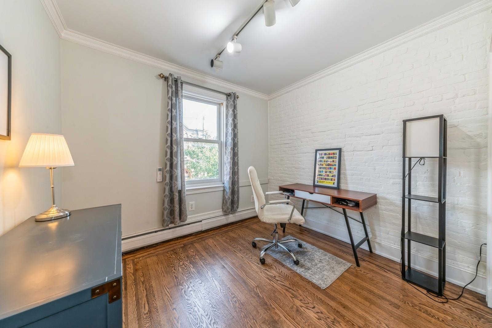 245 3rd Street, Unit 2 Jersey City, NJ 07302 - Photo 11 of 19 a work room with furniture a rug and a window