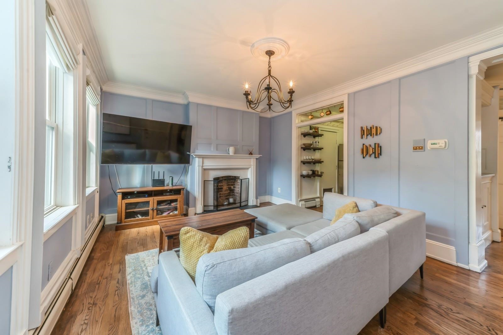 245 3rd Street, Unit 2 Jersey City, NJ 07302 - Photo 3 of 19 a living room with furniture a fireplace and a flat screen tv