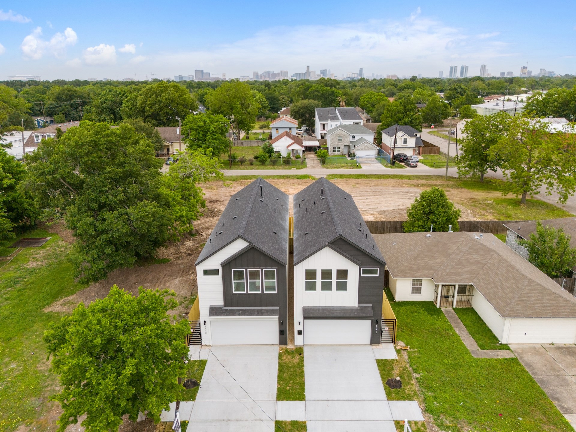 6408 Foster Street Houston, TX 77021 - Photo 37 of 39 Direct aerial view — clean architectural lines, dual two-car driveways, side security gates, and distant skyline views framed by lush green canopy.