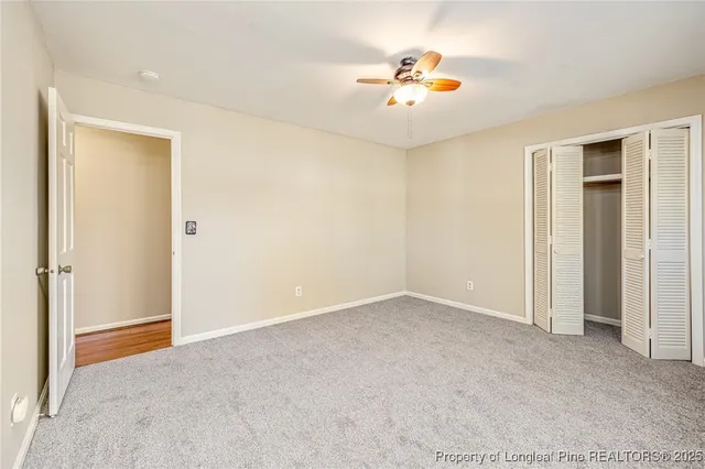 a view of an empty room with a chandelier fan