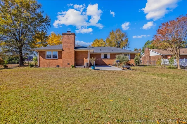 a front view of a house with a yard and trees