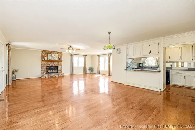 a view of a kitchen with kitchen island a stove a refrigerator cabinets and a counter space
