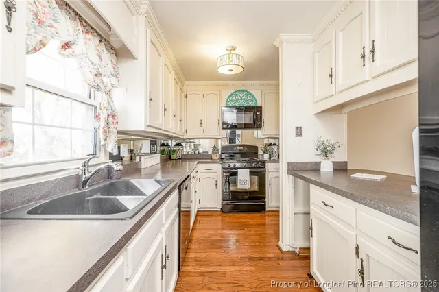 a kitchen with stainless steel appliances granite countertop a sink a stove and a refrigerator