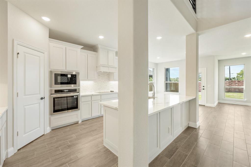 717 Seahawk Street Joshua, TX 76058 - Photo 11 of 40 a view of kitchen with kitchen island white cabinets and stainless steel appliances