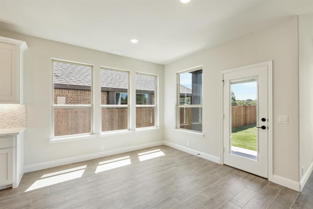 717 Seahawk Street Joshua, TX 76058 - Photo 14 of 40 a view of an empty room with a window and wooden floor