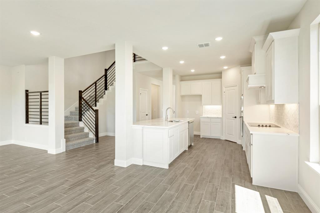 717 Seahawk Street Joshua, TX 76058 - Photo 15 of 40 a large white kitchen with wooden floor and a refrigerator
