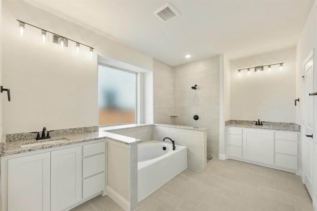 717 Seahawk Street Joshua, TX 76058 - Photo 22 of 40 a bathroom with a granite countertop sink and mirror with bathtub