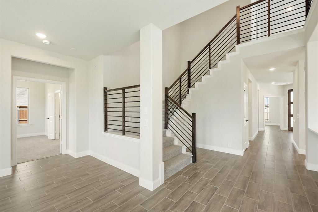 717 Seahawk Street Joshua, TX 76058 - Photo 24 of 40 a view of a hallway with wooden floor and staircase