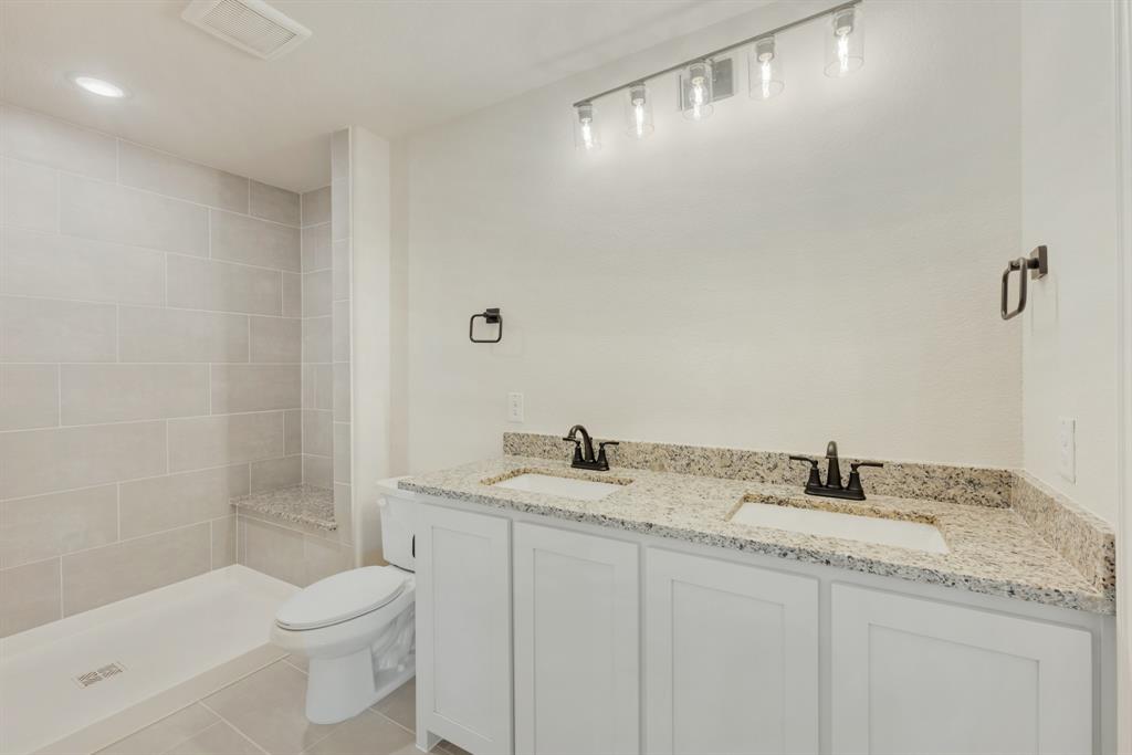 717 Seahawk Street Joshua, TX 76058 - Photo 30 of 40 a bathroom with a granite countertop sink a toilet and shower