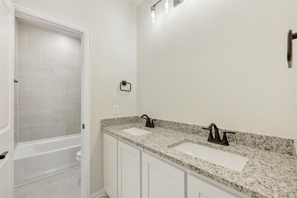 717 Seahawk Street Joshua, TX 76058 - Photo 35 of 40 a bathroom with a granite countertop sink and a mirror