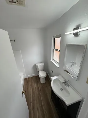 a bathroom with a sink mirror and toilet