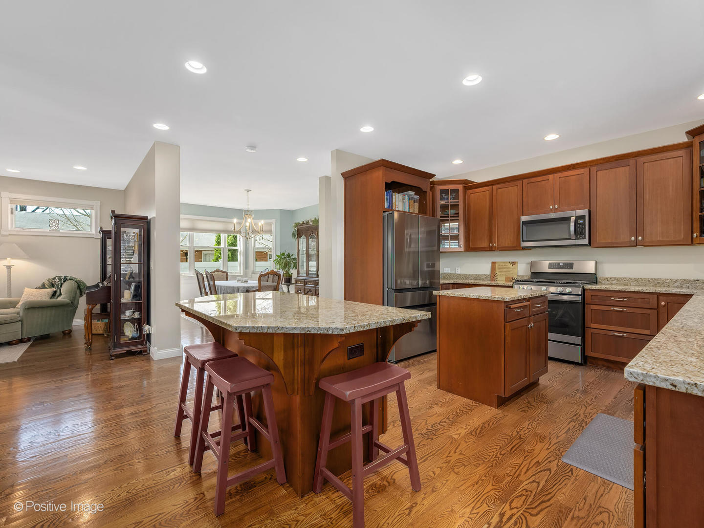 1607 East Indiana Street Wheaton, IL 60187 - Photo 9 of 31 a kitchen with stainless steel appliances kitchen island granite countertop a refrigerator a stove a sink a dining table and chairs with wooden floor