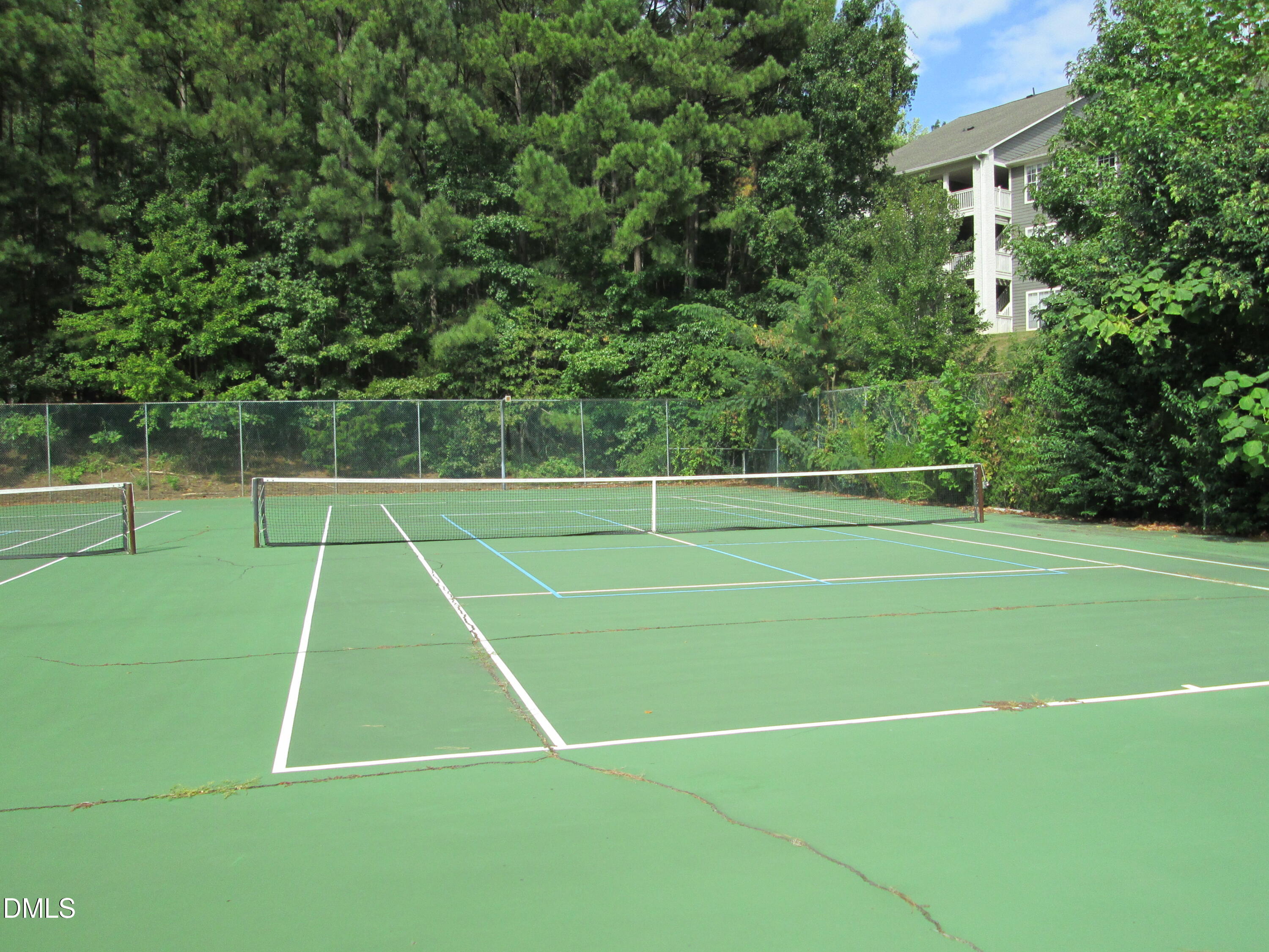 4651 Timbermill Court, Unit 103 Raleigh, NC 27612 - Photo 39 of 40 Tennis court featuring a green playing surface and perimeter fencing