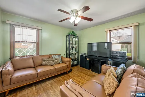 a living room with furniture a flat screen tv and a large window