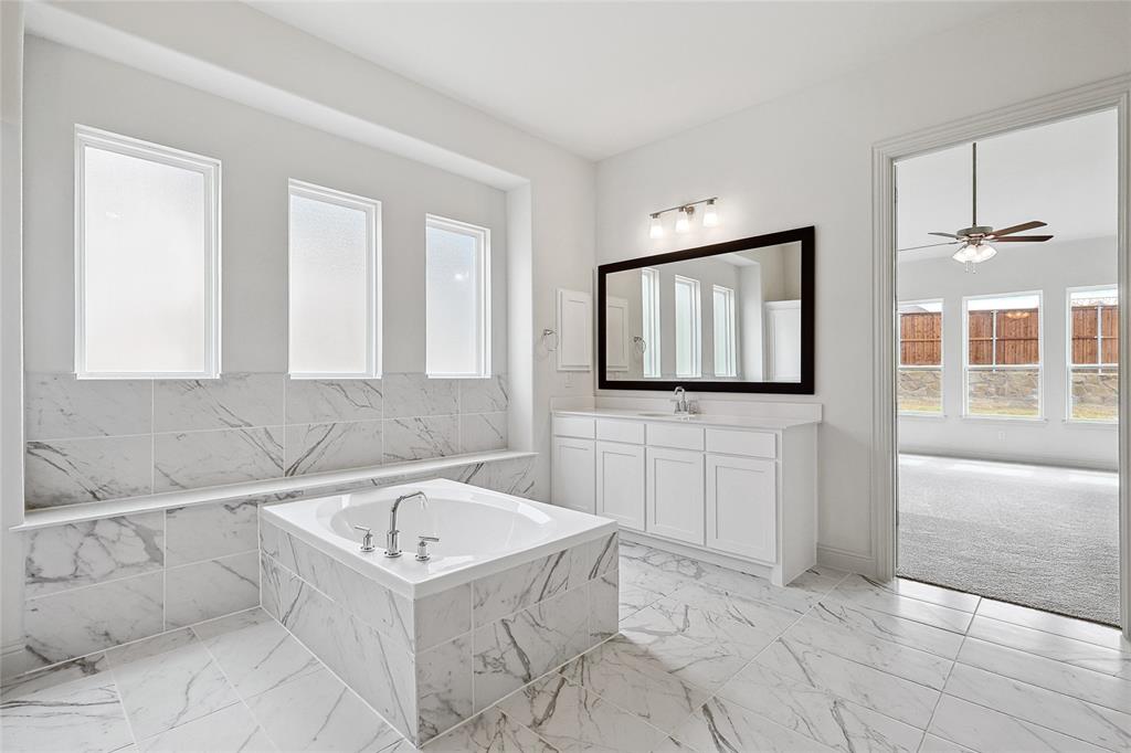 521 Carriage Hl Road Midlothian, TX 76065 - Photo 13 of 26 Bathroom featuring vanity, plenty of natural light, light marble finish floors, and a bath