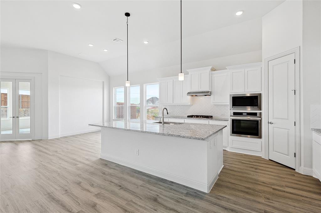 521 Carriage Hl Road Midlothian, TX 76065 - Photo 5 of 26 Kitchen featuring vaulted ceiling, light stone counters, white cabinets, french doors, and stainless steel appliances