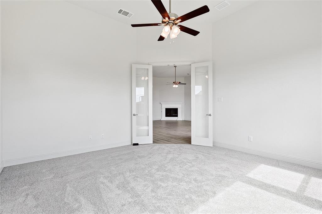 521 Carriage Hl Road Midlothian, TX 76065 - Photo 9 of 26 Carpeted spare room with a fireplace, a high ceiling, and ceiling fan