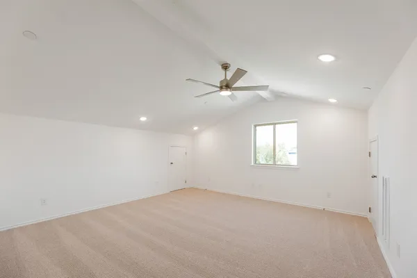an empty room with a ceiling fan and windows