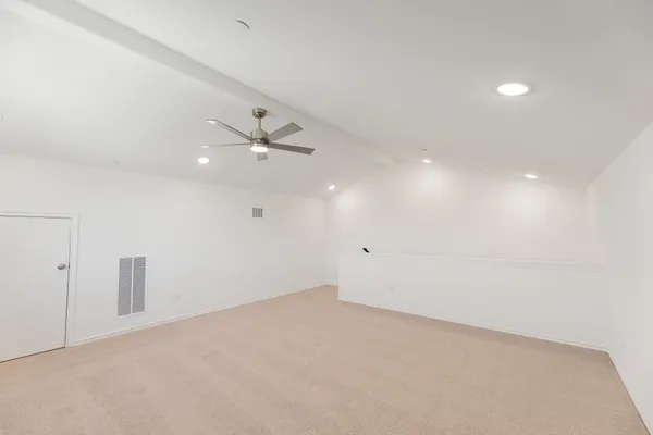an empty room with an entryway and fan