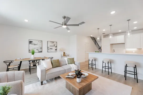 a living room with furniture a rug and white walls