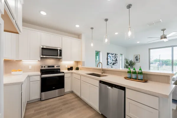 a kitchen with stainless steel appliances granite countertop a sink a stove and cabinets
