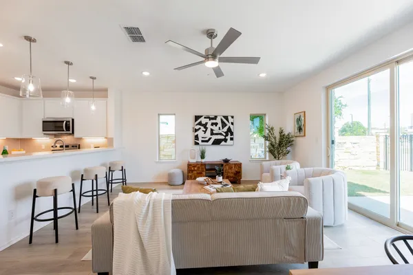 a living room with furniture kitchen and a large window