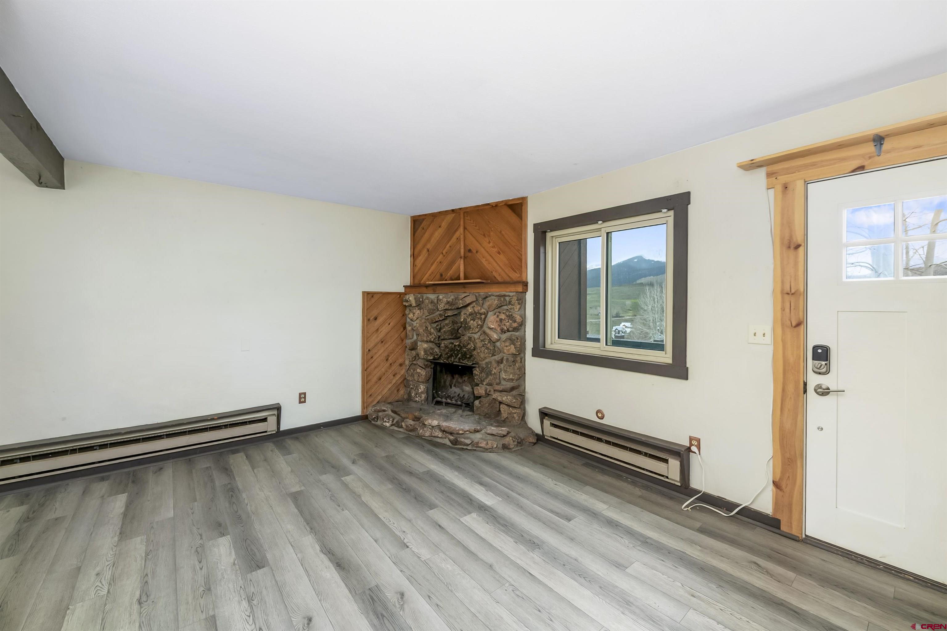 22 Castle Road, Unit 2 Crested Butte, CO 81225 - Photo 16 of 34 an empty room with wooden floor and windows