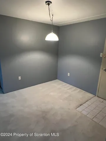 a view of an empty room and a chandelier fan