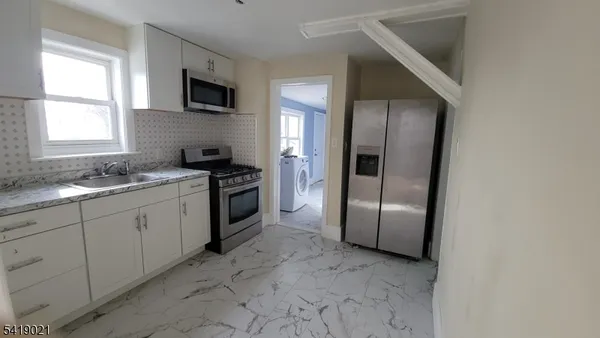 a view of hallway with a large window and wooden floor