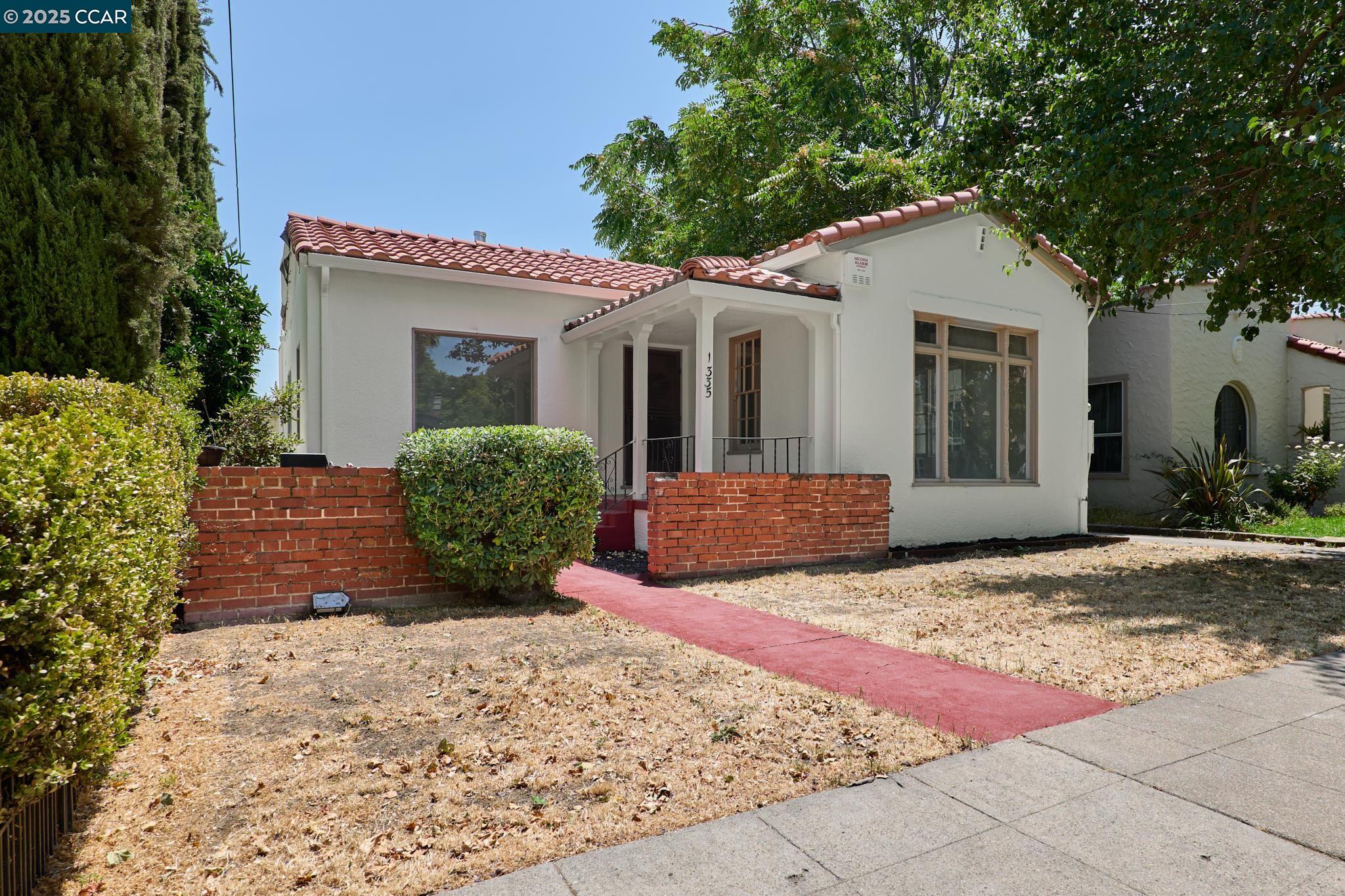 a view of a house with a yard and potted plants
