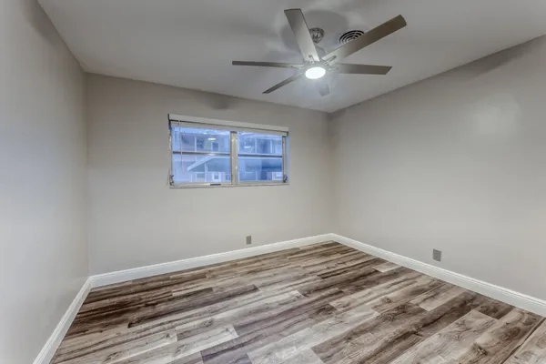 a view of a room with wooden floor and a ceiling fan