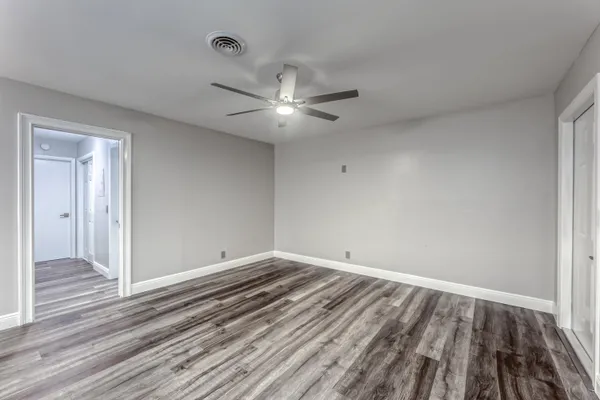 a view of empty room with wooden floor