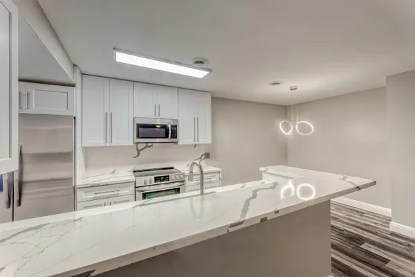 a kitchen with granite countertop a refrigerator sink and stove
