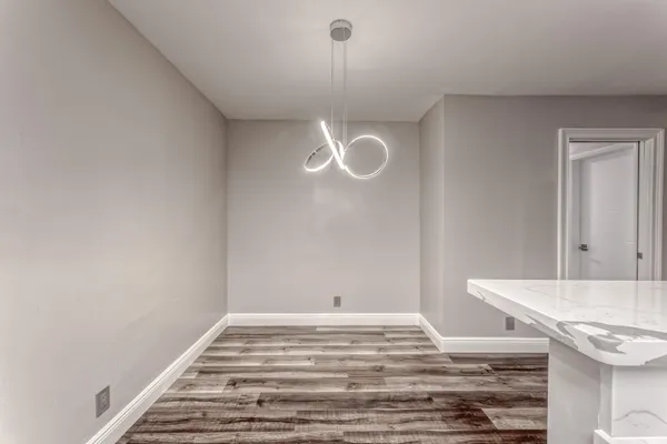 a view of a room with wooden floor and white walls