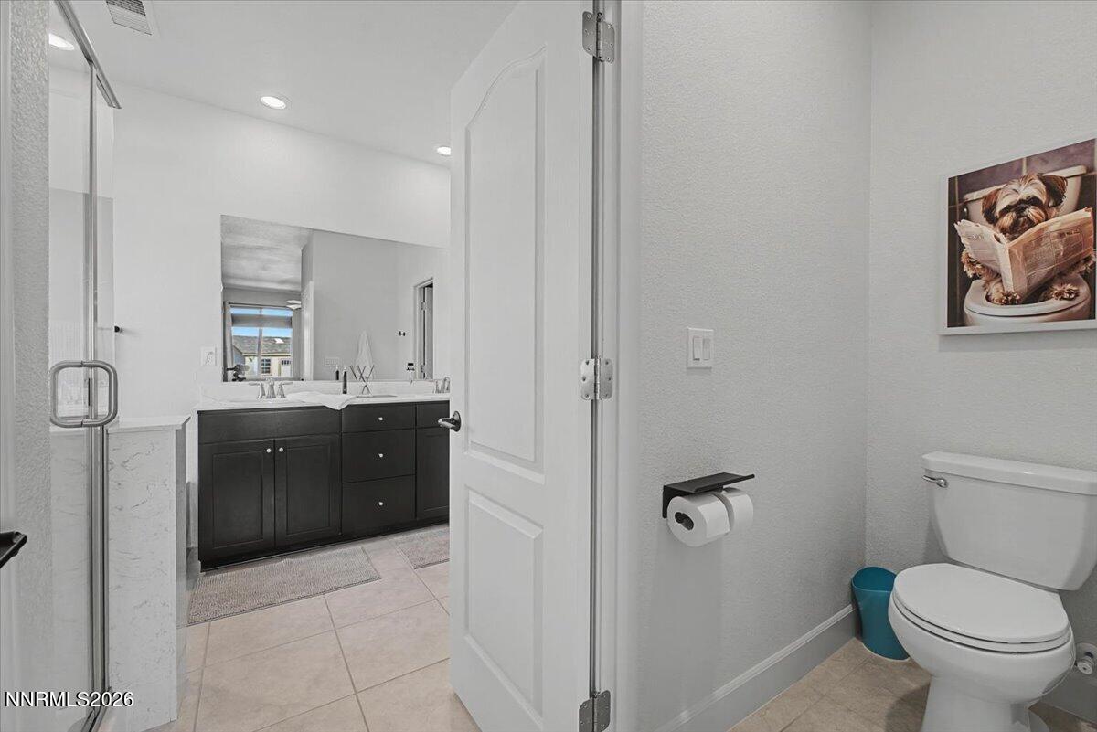 6997 Spencer Ridge Court Sparks, NV 89436 - Photo 15 of 38 a spacious bathroom with a granite countertop toilet sink and mirror