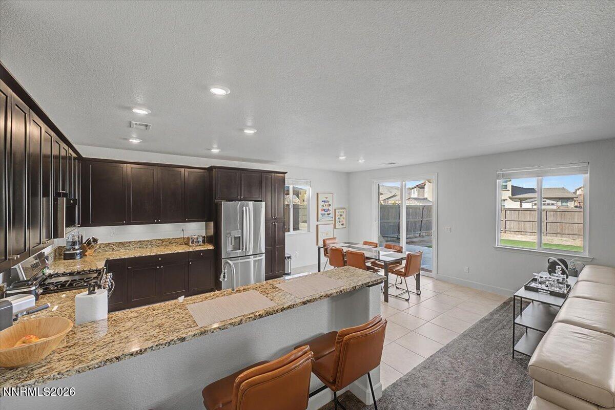 6997 Spencer Ridge Court Sparks, NV 89436 - Photo 3 of 38 a large living room with stainless steel appliances granite countertop a couch a dining table and chairs