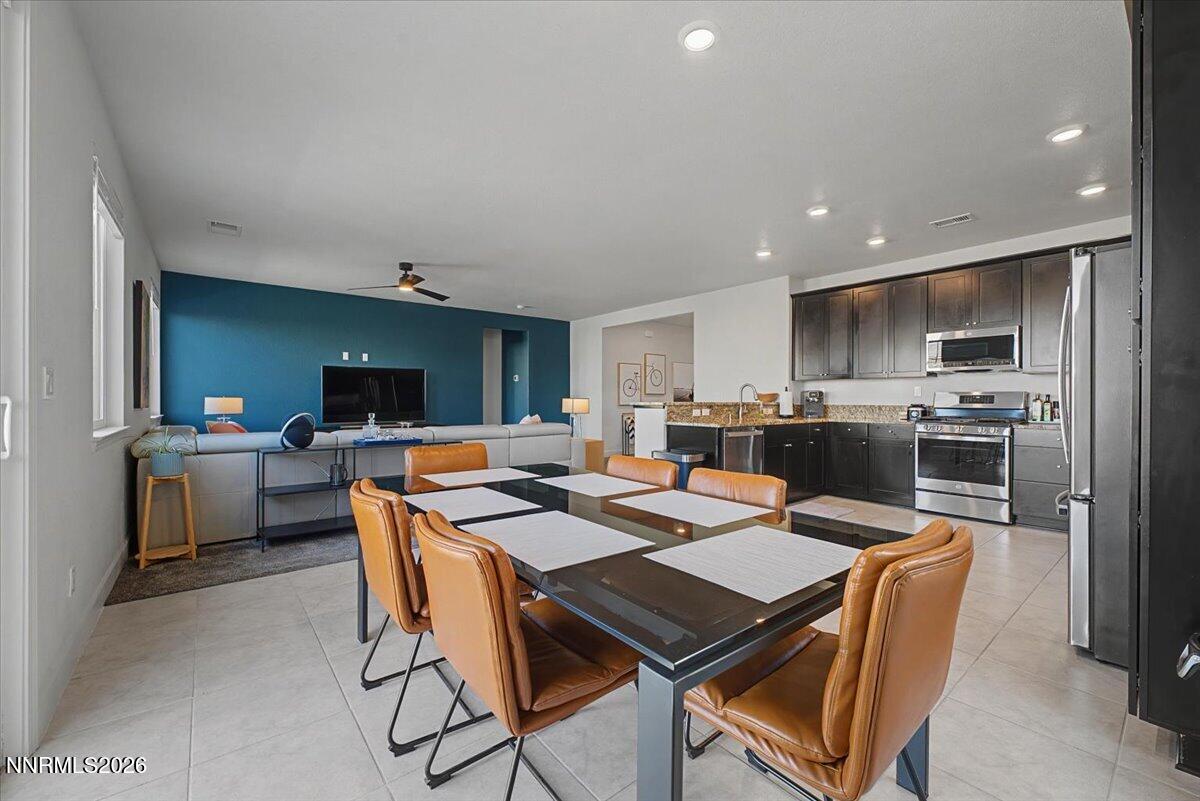 6997 Spencer Ridge Court Sparks, NV 89436 - Photo 5 of 38 a kitchen with a dining table chairs and refrigerator