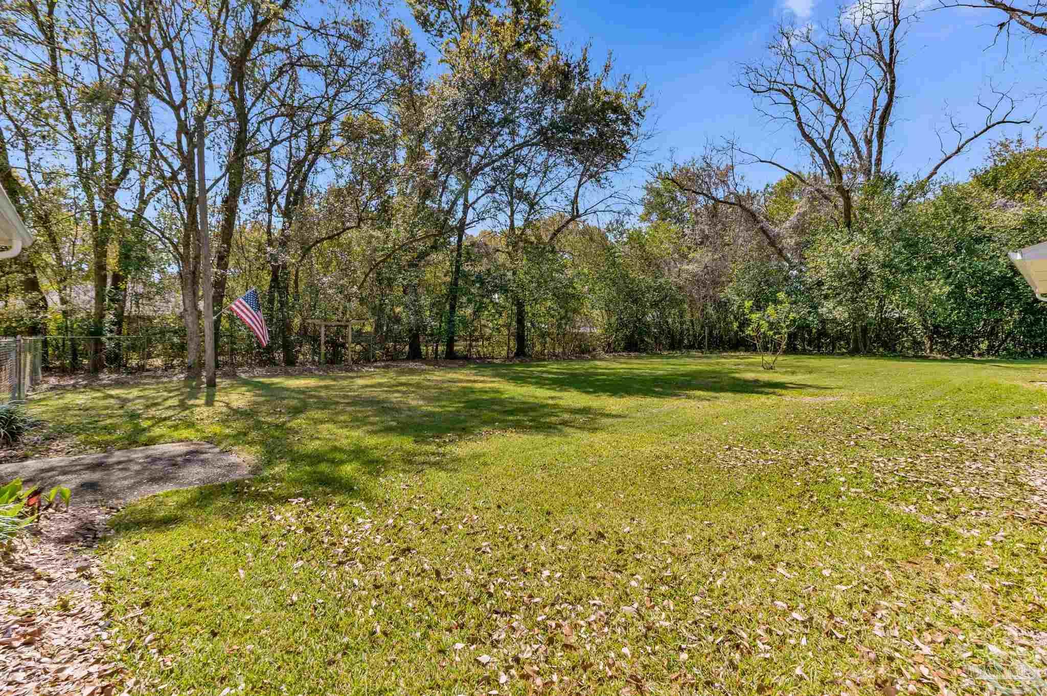 7175 Wallace Drive Pace, FL 32571 - Photo 16 of 71 a view of a field with trees in the background