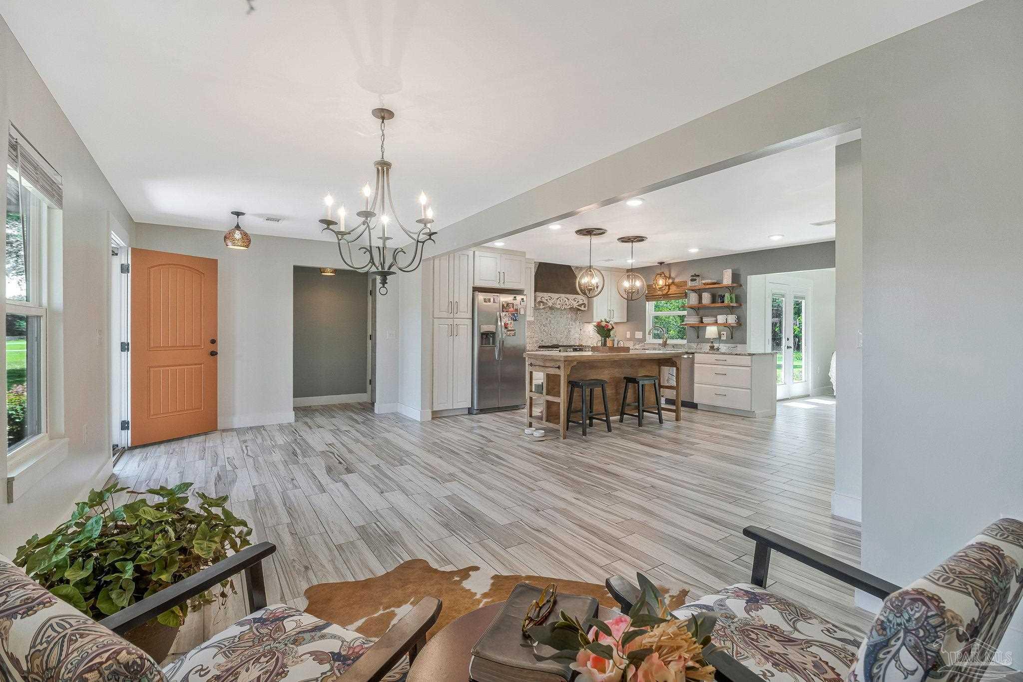 7175 Wallace Drive Pace, FL 32571 - Photo 21 of 71 a view of a livingroom and dining room with furniture wooden floor and chandelier