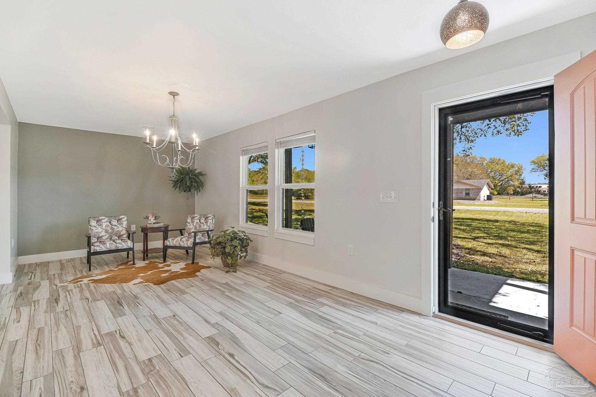 7175 Wallace Drive Pace, FL 32571 - Photo 22 of 71 a dining room with chandelier and wooden floor